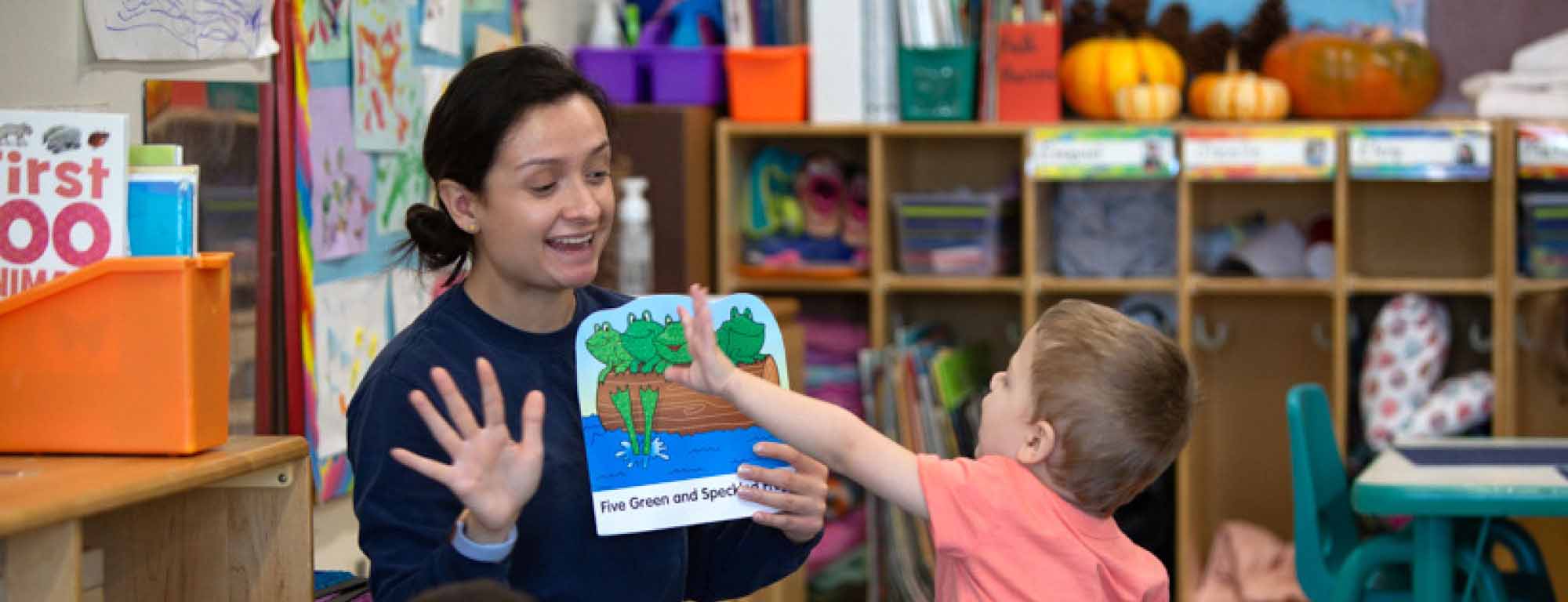 Teacher and children at a table working on a learning activity