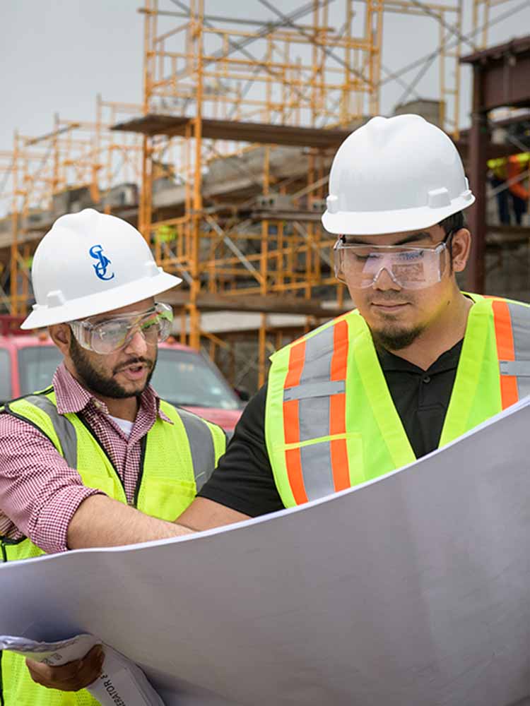 two construction workers looking at blueprints