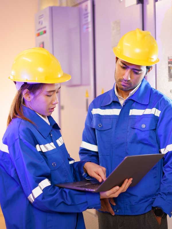 Man and woman looking at clipboard near electrical panel